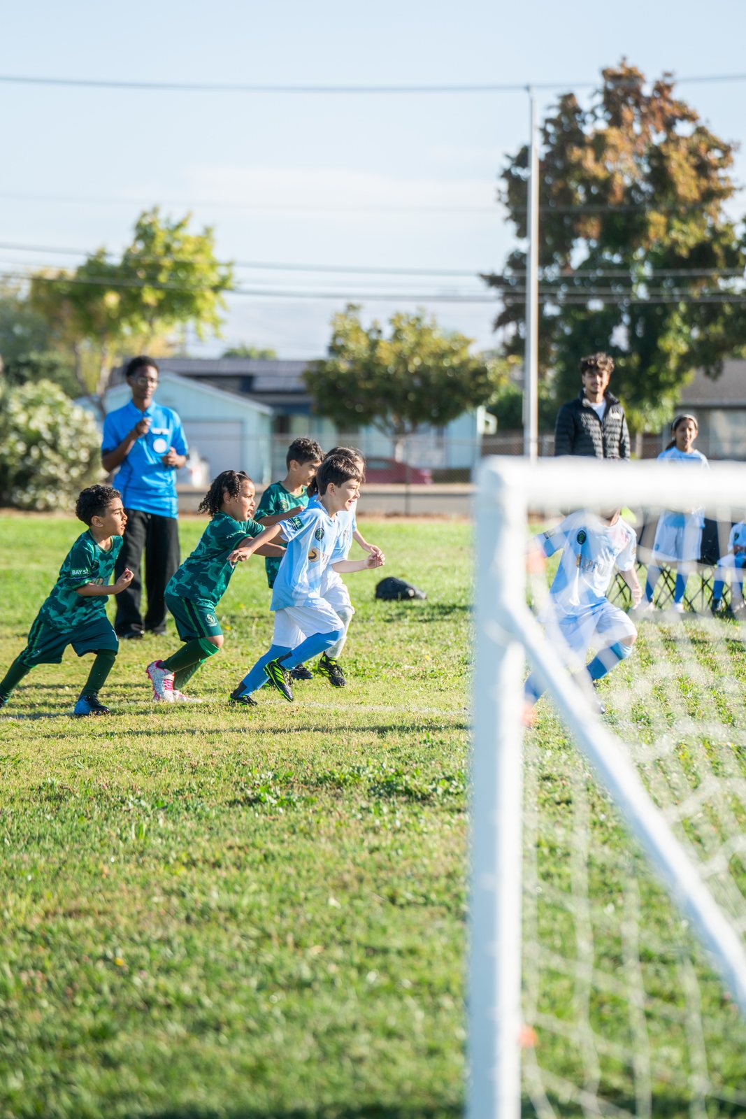Players converging on the ball in front of the goal